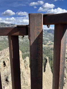 an iron railing with mountains in the background