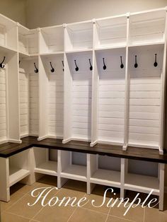 a room with some white wooden benches and hooks on the wall