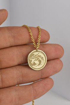 ▪️ A beautiful dragon pendant made out of 14K Real Gold. Available only in yellow gold! ▪️ Pendant Thickness: 0.60mm ▪️ Pendant Dimensions: - 20mm / 0.78 inches - 22mm / 0.86 inches - 24mm / 0.94 inches ▪️ Rope Chain Thickness: 2.10mm Welcome to RedGiftBox, it is our pleasure providing you our fine gold jewelry! Style 3(Rope Chain): - 14K Real Gold - 2.10mm Thickness - Spring Ring Clasp Weight per length: 40CM / 15.7 Inches - 2.05 grams 45CM / 17.7 Inches - 2.26 grams 50CM / 19.7 Inches - 2.47 g Round Dragon Design Necklace For Gift, Round Dragon Design Jewelry For Gifts, Dragon Design Jewelry For Gift, Dragon Design Jewelry Gift, Symbolic Gold Dragon Jewelry, Symbolic Gold Jewelry With Dragon Design, Gold Necklace With Dragon Design Collectible, Yellow Gold Dragon Design Jewelry Gift, Gold Dragon Design Jewelry