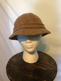 1980s Kangol made in England brown herringbone bucket hat: This Kangol hat is wool. It is labeled a size medium. The circumference at the inner band is 21 in. Retro Wide Brim Cloche Hat For Winter, Vintage Winter Brimmed Cloche Hat, Vintage Brimmed Cloche Hat For Winter, Winter Vintage Brimmed Cloche Hat, Retro Winter Cloche Hat With Short Brim, Vintage Wool Cloche Hat With Short Brim, Wool Bucket Hat With Curved Brim For Fall, Vintage Cloche Hat With Curved Brim For Fall, Brown Herringbone Pattern Hat For Fall