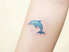 a small dolphin tattoo on the arm