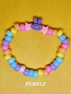 ""Kawaii" is a word that describes a style of art, design, and behavior that conveys cuteness, innocence, and joy." (Merriam-Webster). This Bunny Kandi Bracelet bracelet exemplifies what kawaii is with its adorable bunny beads and pastel colors.  This handmade bracelet is 18cm. (7in.) in length and is made with plastic and acrylic beads. The pony beads seen are the standard 5mm size, whereas the bunny and star beads are 10mm and 8mm respectively. The whole piece is tied together with a stretchy, yet durable, elastic cord. The bracelet is lightweight and is comfortable to wear.  This kandi bracelet is suitable for any ocassion and would be a great gift for anyone who is into a more kawaii aesthetic or kawaiicore fashion. Anyone can wear this piece regardless of age, gender, or orientation. Cute Plastic Stretch Bracelet As Gift, Cute Plastic Stretch Bracelet Gift, Adjustable Kawaii Beaded Bracelet For Birthday, Cute Plastic Bracelets For Birthday, Cute Rainbow Bracelets For Birthday, Cute Colorful Adjustable Stretch Bracelet, Adjustable Pastel Beaded Bracelets Playful Style, Cute Colorful Beaded Bracelets, Adjustable Cute Kawaii Jewelry