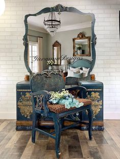 an ornate blue chair sits in front of a mirror