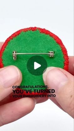 someone holding a green and red button with the words congratulations you've turned your embroidery into