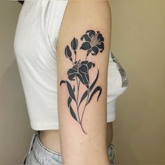 a black and white flower tattoo on the left upper half of the arm is shown