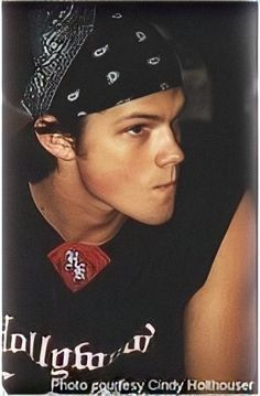 a young man wearing a black shirt and bandana