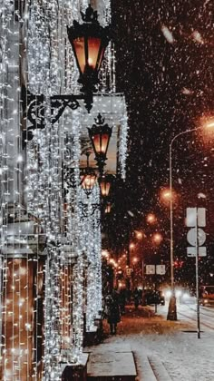 a street light covered in snow next to a building with lots of lights on it