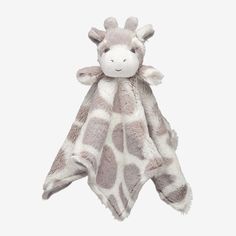 a stuffed giraffe laying on top of a blanket