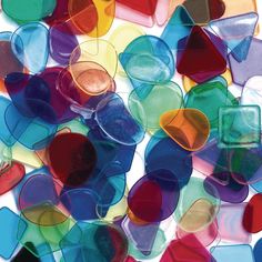 multicolored glass hearts are scattered on a white surface