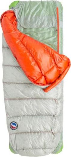 an orange sleeping bag sitting on top of a white blanket