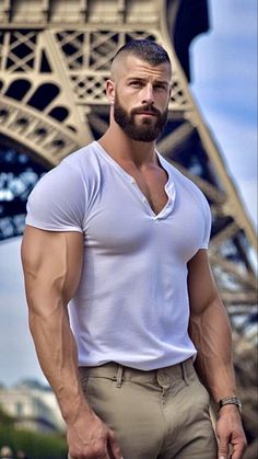 a man standing in front of the eiffel tower with his hands on his hips