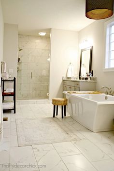 a white bathroom with a tub, sink and shower stall in it's corner