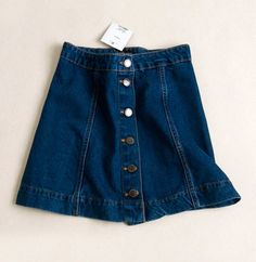 Haven't got the latest button-down denim skirt yet? Swap your boring mini skirts with this on-trend piece!This denim skirt featuring a button-down detail is one of the most popular trend RN in 2016. The A-line and high-waisted details can help elongate your legs and make your waist looks smaller. Style this minis with turtleneck top and wedges for that retro 60's vibes! Not comfortable in flashing.. Summer Button-up Denim Skirt In Denim Blue, Summer Button-up Denim Blue Denim Skirt, Summer Button-up Denim Blue Skirt, Casual Mini Skirt With Button Zip Fly, Dark Wash Cotton Skirt With Button Zip Fly, Summer Denim Skirt With Buttons, Denim Button Skirt For Summer, Summer Denim Blue Skirt With Buttons, Denim Blue Button Skirt For Summer