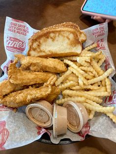 fried chicken, french fries and coleslaw on a plate with a cell phone