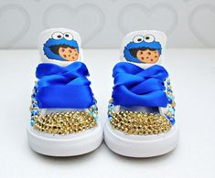 a pair of shoes with blue and gold sequins on them, decorated with an image of cookie monster