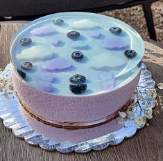 a cake with blueberries on top sitting on a table