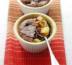 two bowls filled with food sitting on top of a red place mat next to a spoon