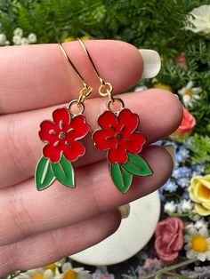 "Red flower earrings with green leaves and golden details. *Length (using default ear hooks): 1.75\"  *Weight (approx, each): 2g ✨Upgradable earring options available are: Gauge sizes are approximate, batches may vary. Some options may be in limited supply and may take additional time to ship.  *304 Steel mini hooks, silver color, 22 gauge (0.7mm). This is the perfect option for anyone with smaller lobes or with low piercings.  *316L Steel hooks, silver color, 21 gauge (0.8mm).  *Golden steel ho Red Flower Charm Earrings, Red Flower Earrings With Ear Wire, Red Flower Drop Earrings, Flower Shaped Earrings With French Hook For Gift, Red Drop Earrings With Flower Charm, Flower-shaped Earrings With French Hook As Gift, Red Birth Flower Earrings For Gift, Red Flower Earrings With Ear Wire For Gift, Red Dangle Earrings With Flower Charm