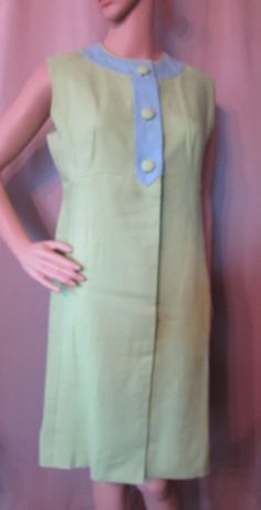 "LAST CALL! 50% OFF! Offered is an attractive vintage summer dress that is as fashionable today as it was decades ago. It is a sleeveless sheath in color block combination of lime green and sky blue. The blue plays at the banded neckline forming a front placket with large lime fabric buttons. Below the waist the lime green dress closes with 2 large hidden snaps. This has an empire waistline. The cut is generally a princess cut with a front pleat panel for the skirt. The back is equally handsome Green Lined Vintage Dress For Summer, Green Lined Vintage Summer Dress, Blue Retro Vintage Dress For Summer, Green Vintage Style Dress For Summer, Green Vintage Dress For Summer, Vintage Sheath Dress For Spring, Green Summer Dresses In Vintage Style, Green Summer Dresses For Vintage Fashion, Green Summer Dress For Vintage Fashion