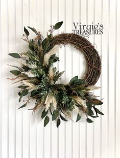 a wreath hanging on the side of a wall with dried grass and leaves around it