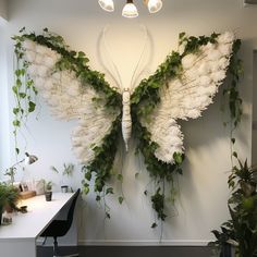 an office decorated with white flowers and greenery in the shape of a large butterfly