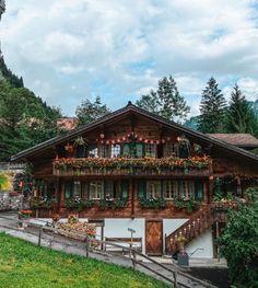 an old wooden house with flowers on the balconies