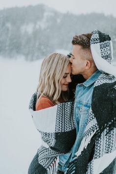 a man and woman are hugging in the snow