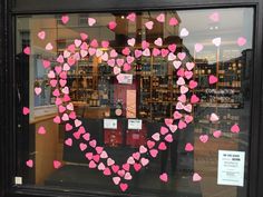 a store window with pink and red hearts on it