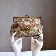 A gorgeous, fully beaded vintage circa 1920s/30s evening bag. Soft biege body covered on the front and back in a lovely deco floral motif of roses and geometric designs, in pink, purple, burgundy, gray and white. Hard-frame metal mouth and chain strap with lovely patina. Fully lined in a natural woven cream fabric. A lovely petite, dressy, size but should be room enough for a couple essentials and most phones (my Pixel 4 just fits inside nicely).  ❣ Measurements, Condition & Label Info ❣   Measures: 8" by 5" at the widest points Capacity width: about 2" Strap drop: 7" Label: none Condition: Very good vintage condition | There is wear / patina to the metal portions of the mouth and chain strap (which I think looks quite charming) and scattered age spots to the lining of the bag (I have not Vintage Bags, Geometric Designs, Chain Strap, Clutch Handbag, Floral Motif, Evening Bags, Purses And Handbags, Art Deco, Accessory Gift