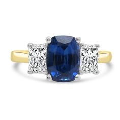 an oval blue sapphire and three princess cut diamond ring