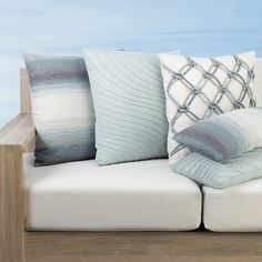 a couch with several pillows on it and a wooden table in front of the couch