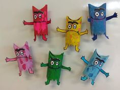 six different colored paper monsters on a white surface