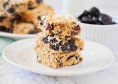 three pieces of oatmeal bars stacked on top of each other with raisins and blueberries