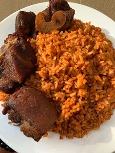 a white plate topped with rice and meat next to other food on top of a table