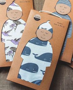 three tags with pictures of children in blue and white clothing on them, one has a baby's head