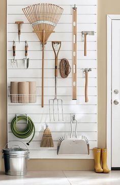 a white wall filled with lots of different tools and items hanging on it's side