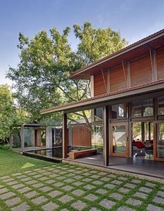 a modern house with large windows and grass