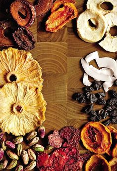 an assortment of dried fruits and nuts on a wooden surface