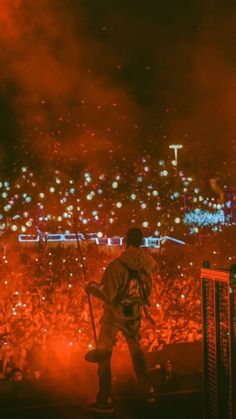 a man standing on top of a stage in front of a crowd at a concert