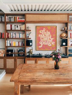 a wooden table sitting in front of a book shelf filled with books