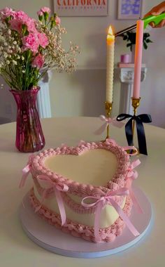 a cake sitting on top of a table next to a vase filled with flowers