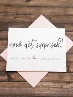 a card with the words now at surprise written on it next to some pink envelopes