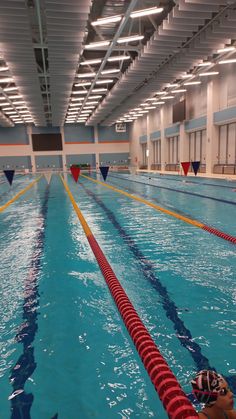 an indoor swimming pool with blue water and yellow lines