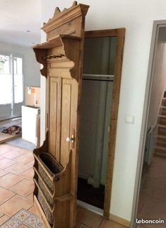 an old wooden armoire sitting in the middle of a room with tile flooring