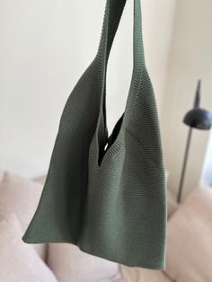 a green bag hanging from a hook in a living room