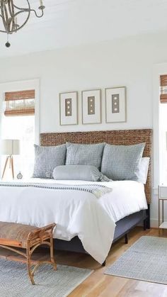 a bedroom with white walls and wood floors, including a bed in the center surrounded by pictures on the wall