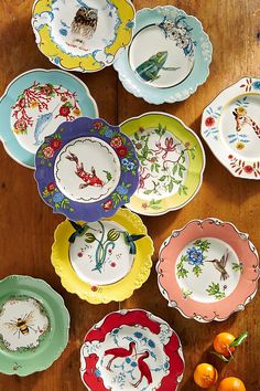 many different colored plates on a wooden table