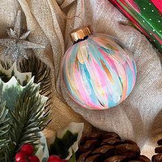 a glass ornament sitting on top of a table next to pine cones