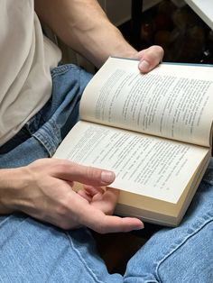 a person sitting down holding an open book