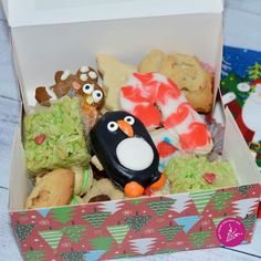 a box filled with lots of different types of cookies and pastries on top of a table